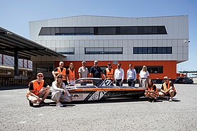 Studenci z zespołu aCentauri Solar Racing Team z ETH Zurich prezentują swój pojazd solarny w terminalu Air & Sea w Wolfurt – w towarzystwie przedstawicieli firmy Gebrüder Weiss.